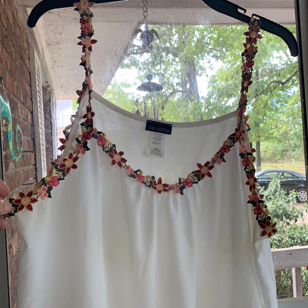 Cute white tank top camisole with flowered accents.